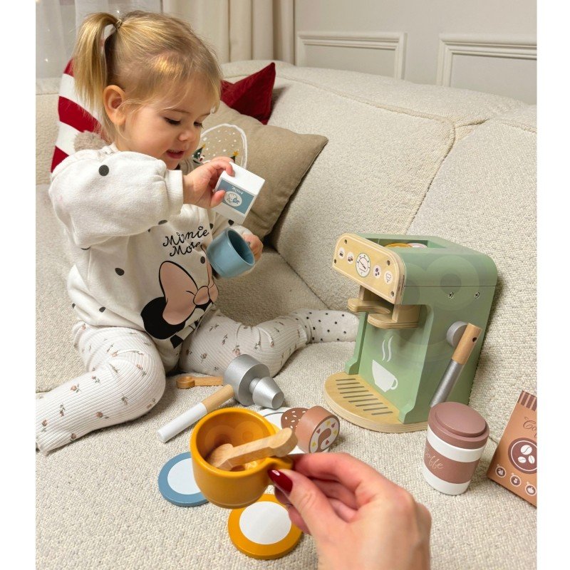 1. Child playing with Woopie Green barista set on sofa with coffee machine and accessories