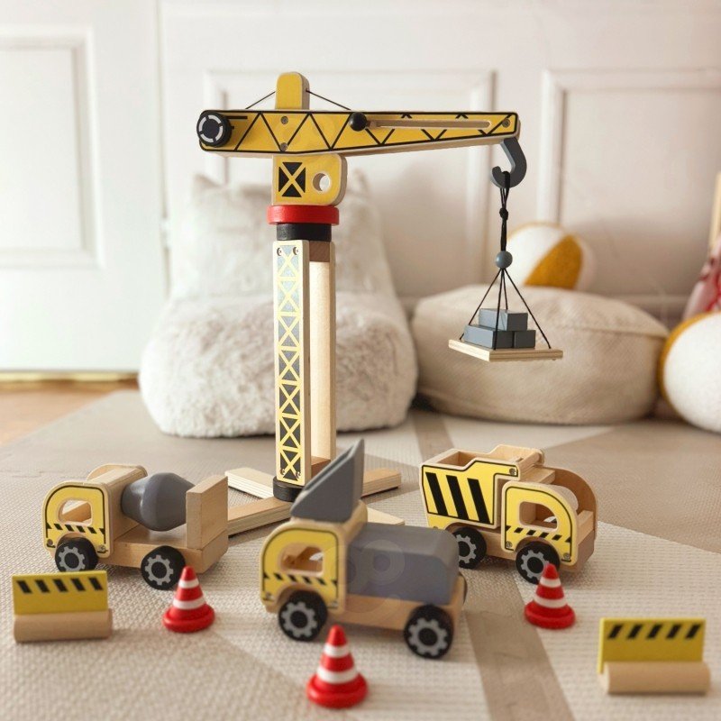 1. Child playing with Woopie Green wooden construction set featuring crane and vehicles on a play mat