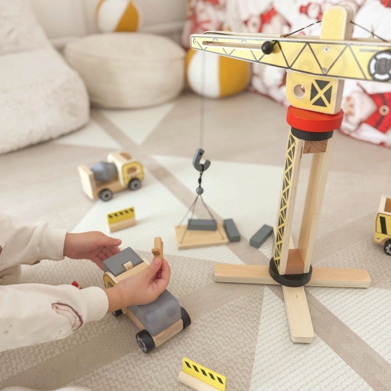 15. Child assembling Woopie Green wooden construction set on a play mat