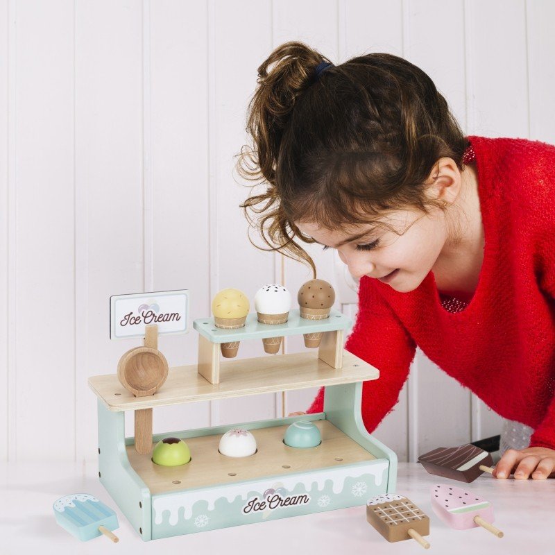 12. Girl in red sweater arranging Woopie Green ice cream stand with cones and popsicles