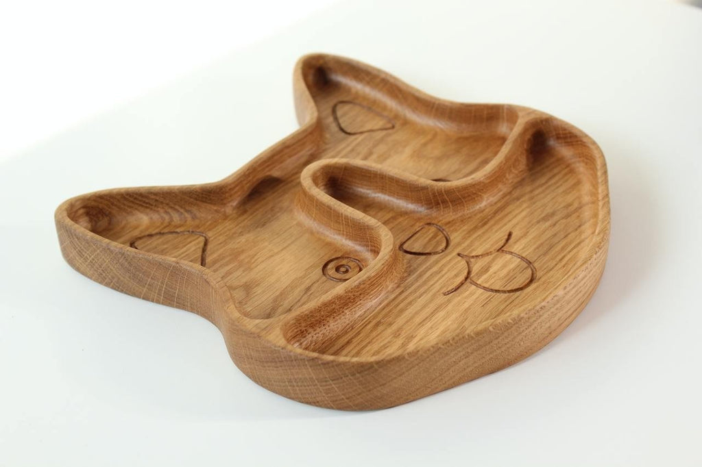 4. Angled view of corgi-shaped wooden plate for kids, displaying the two sectors and engraved details, on a white background.