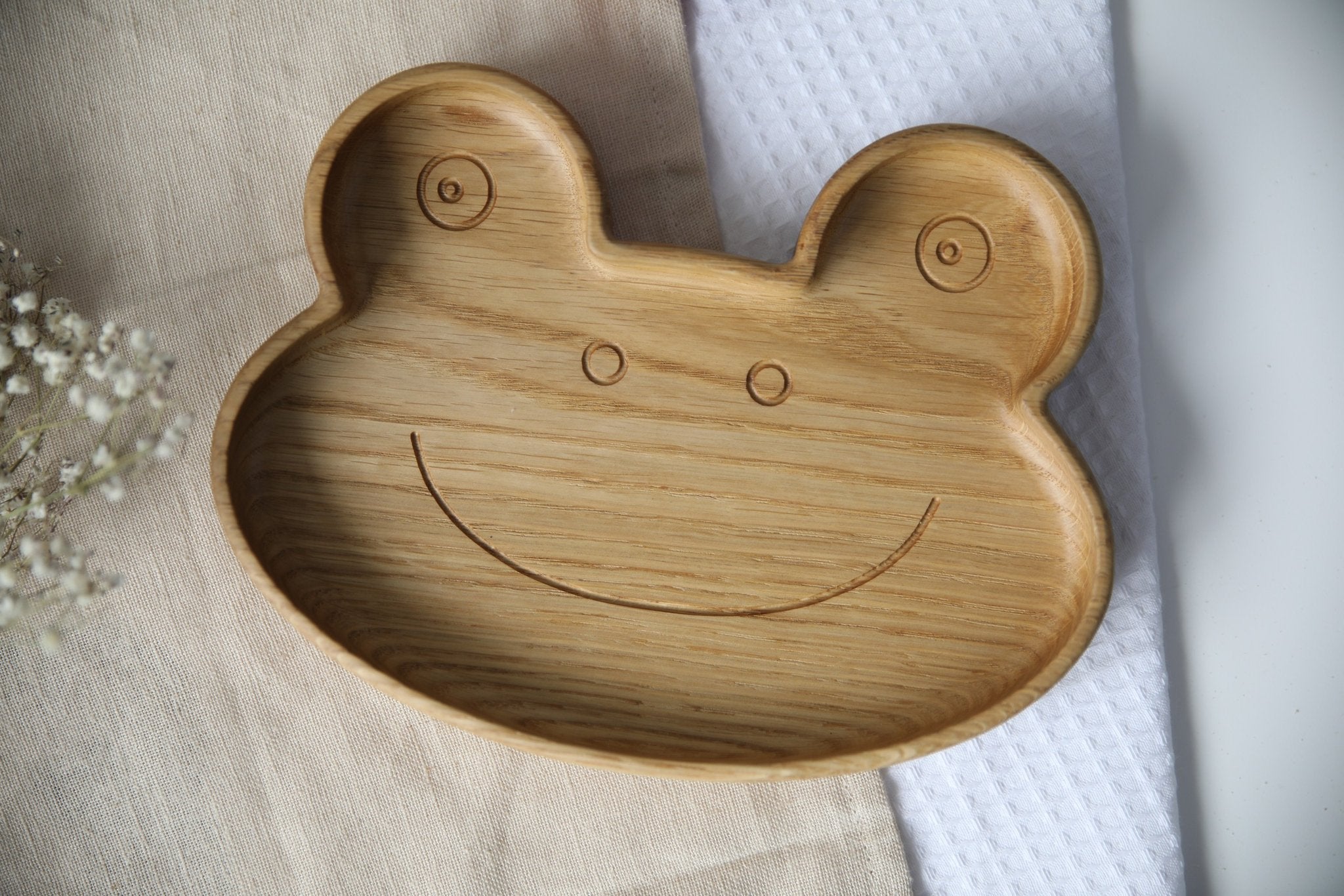 2. Close-up of wooden frog-shaped plate highlighting smooth, polished surface and carved smile