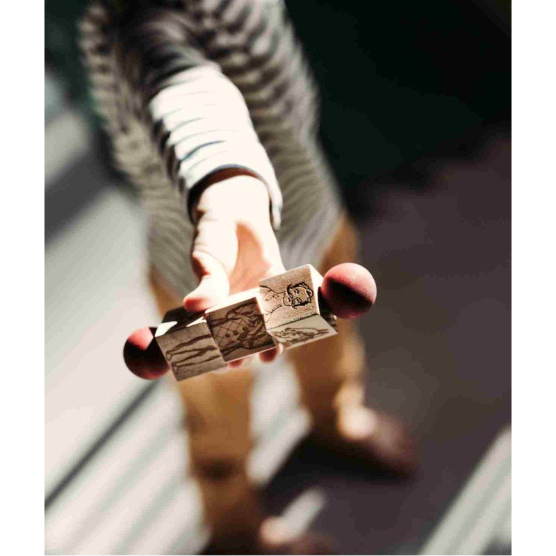 5. Child holding out a colorful wooden spinning puzzle with red ends